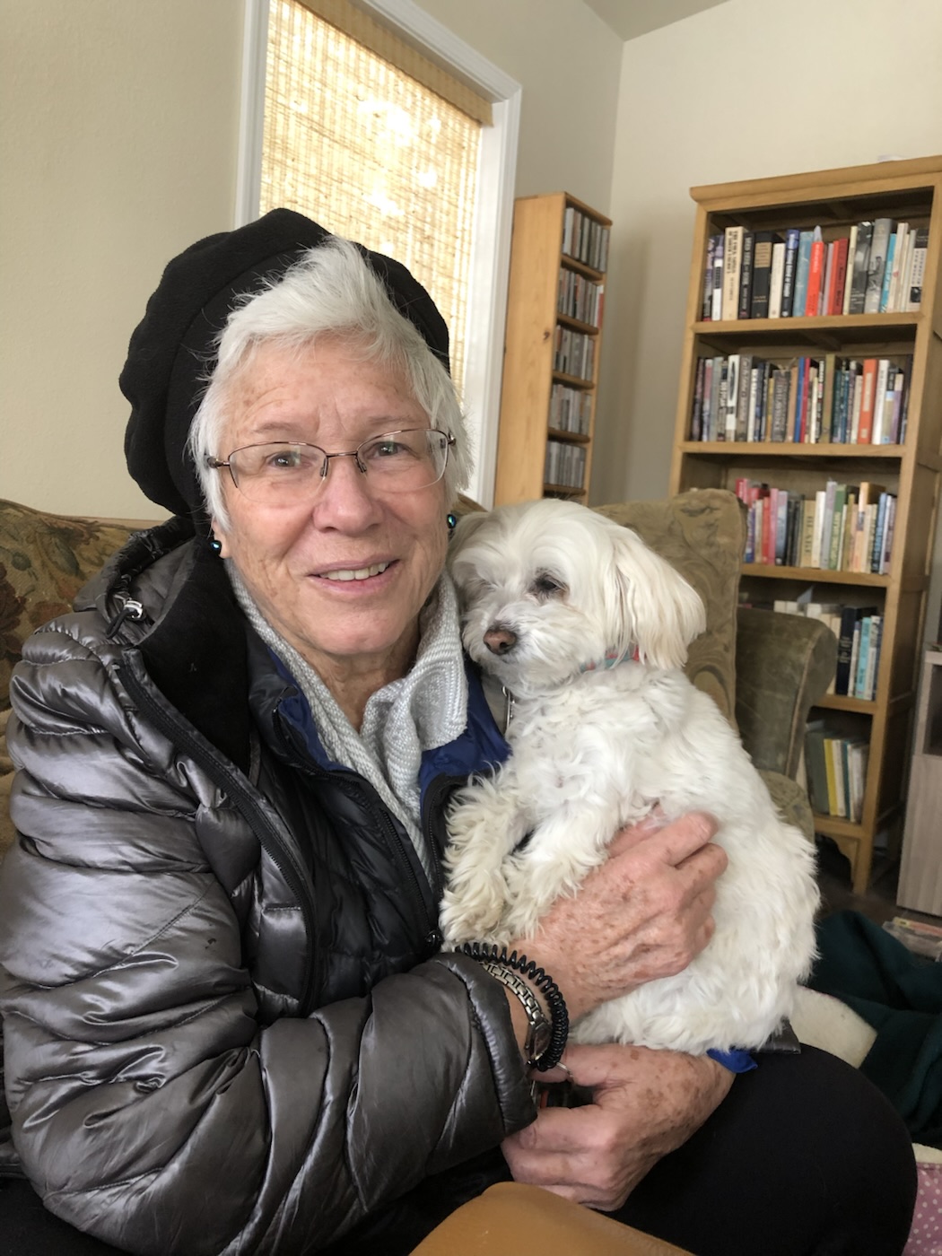 An older woman sitting with a dog