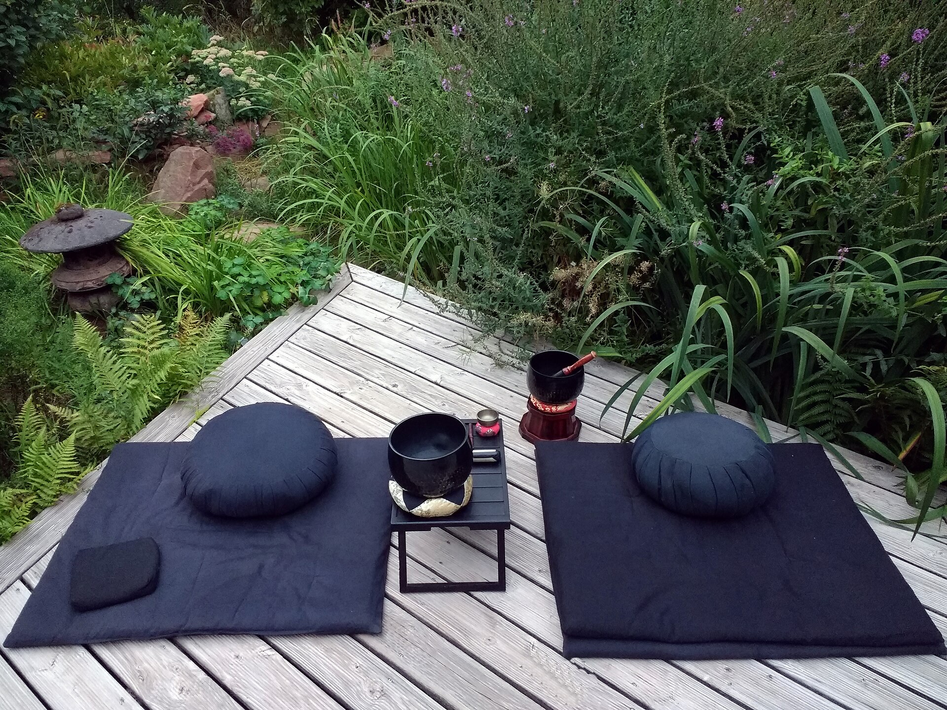 Meditation cushions on a mat in a garden